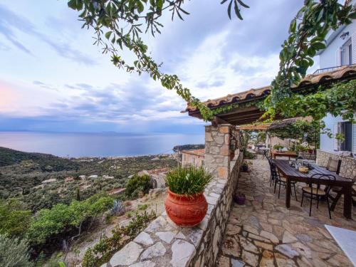 a patio with a table and a view of the ocean at Castle of Himara in Himare