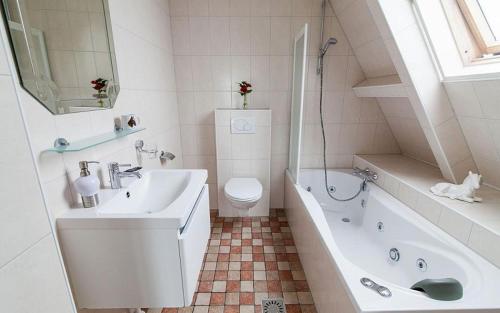 een badkamer met een wastafel, een bad en een toilet bij Farm Overleekerhoeve in Monnickendam