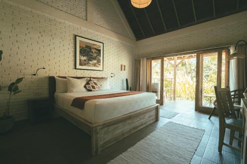 een slaapkamer met een groot bed en een raam bij CARI Surf Camp & Studio's in Uluwatu