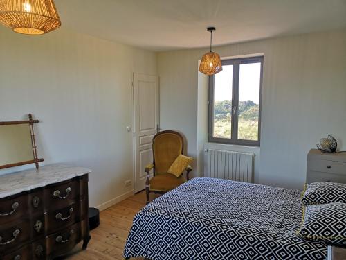 a bedroom with a bed and a dresser and a window at Villa Thérèse in Beaulieu-sur-Dordogne