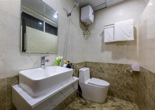 a bathroom with a sink and a toilet at Cat Ba Hongkong Hotel in Cat Ba