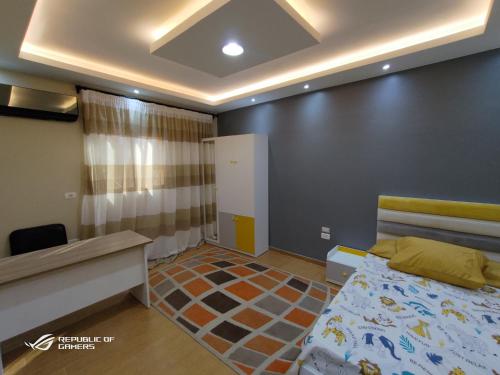 Cet appartement comprend une chambre avec un lit et un bureau ainsi qu'une chambre dotée d'un siège social. dans l'établissement 3 Bedrooms Luxurious Appartment in Nasr City, au Caire