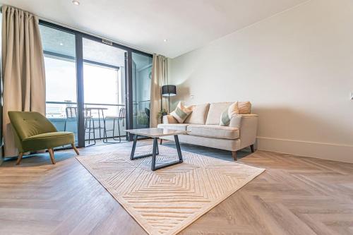 a living room with a couch and a table at 1BR Apt - Balcony - River View in Liverpool