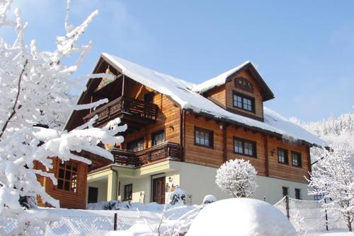 Una gran casa de madera con nieve. en Willa Stareczka, en Wisła