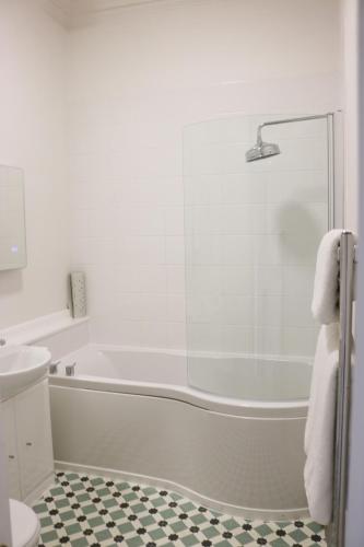 a white bathroom with a tub and a shower at Bartley Lodge Hotel in Lyndhurst
