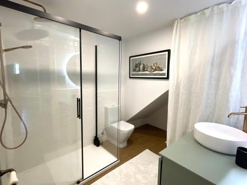 een badkamer met een glazen douche en een toilet bij GURAH Boutique Apartments in Bakio