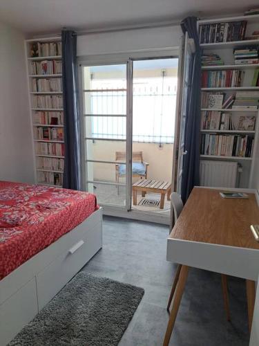 - une chambre avec un lit, une table et des étagères dans l'établissement Appartement cosy avec jardin et parking, à Gennevilliers