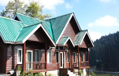 a wooden house with a green roof at Gulmarg Woods By Stay Pattern in Gulmarg