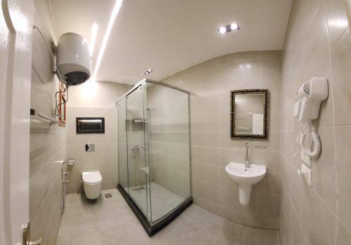 een badkamer met een douche, een toilet en een wastafel bij Wa set Luxor Apartment in Luxor