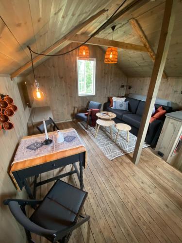 a living room with a couch and a table at Unik overnatting i Stabbur/Minihus in Lunde