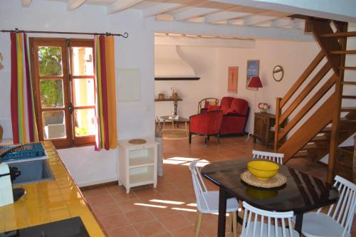 a kitchen and living room with a table and chairs at Mas Sant Jordi in Alénya