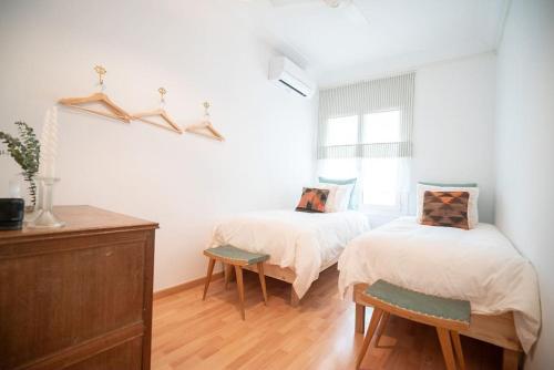 um quarto com 2 camas e uma janela em Stunning Designer 2 Bed Apt in Glorious Gràcia em Barcelona