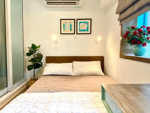 a bedroom with a bed with a vase of flowers at 8 minutes walking to Nguyen Hue, Fast Wifi, check-in 24/7 in Ho Chi Minh City