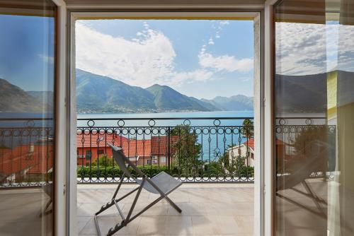 a balcony with a chair and a view of the water at 2montenegro MIMOZA Apartments in Dobrota