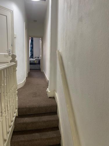 un long couloir avec des escaliers dans une maison dans l'établissement Confortable and central room, à Londres