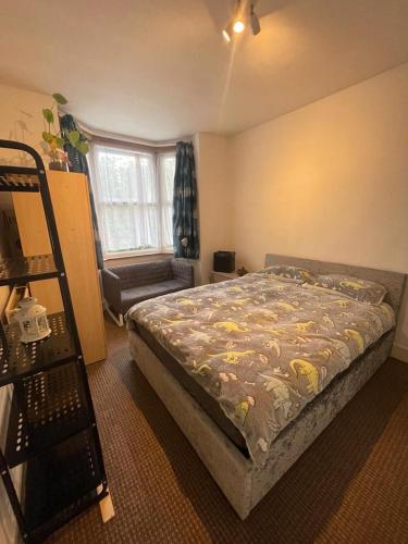Confortable and central room في لندن: غرفة نوم بسرير وكرسي ونافذة