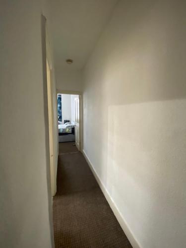 un couloir avec un mur blanc et un couloir blanc dans l'établissement Confortable and central room, à Londres