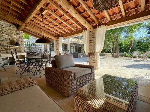 a patio with a couch and chairs and a table at La Serre Des Mourgues in Méjannes-lès-Alès