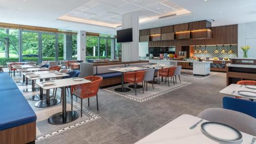 a restaurant with tables and chairs and a bar at Holiday Inn Express Wenchang by IHG in Wenchang