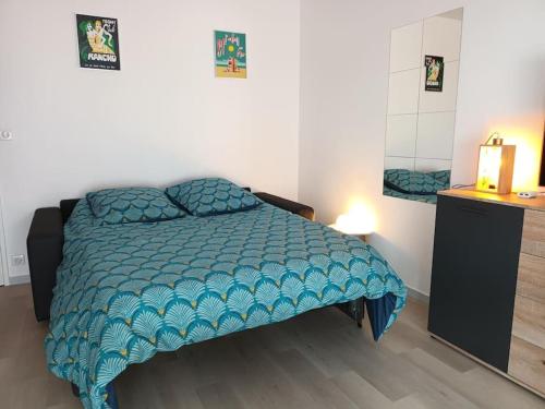 Un dormitorio con una cama con un edredón azul. en Appartement Le Grain de Sable, en Saint-Palais-sur-Mer