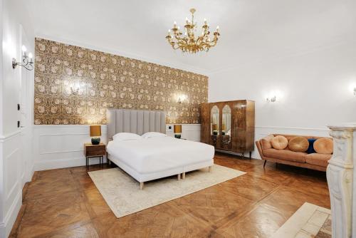 une chambre avec un lit blanc et un canapé dans l'établissement Exceptional apartment - 3BR-8P - Pantheon, à Paris
