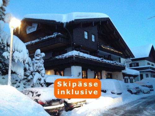 a building covered in snow with a sign on it at Kur- und Ferienhotel Haser in Oberstaufen
