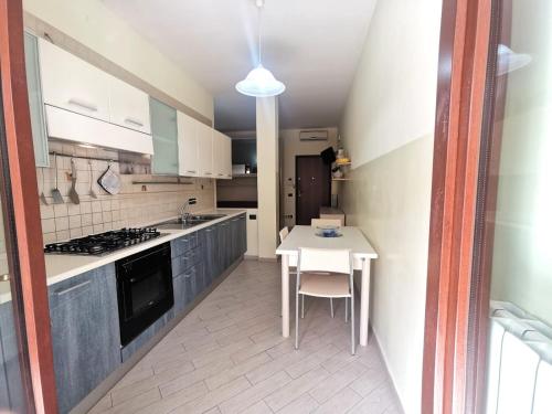 a kitchen with a white table and a white table and chairs at Appartamenti Rosa Virginia by Salentoville Gallipoli in Gallipoli