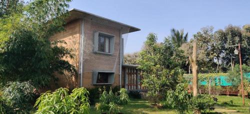 una casa de ladrillo con una ventana en un patio en Serene meadows villa en Bangalore