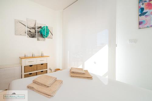 une chambre blanche avec un lit avec des serviettes dessus dans l'établissement Luxury 2 Bed 2 Bath Apartment with pool, à El Campello