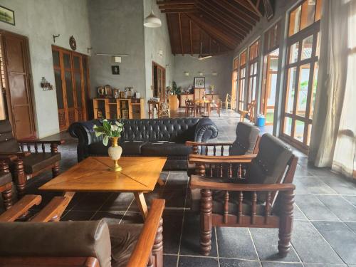 a living room with a couch and tables and chairs at Serene meadows villa in Bangalore