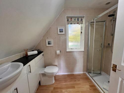 a bathroom with a shower and a toilet and a sink at 44 Trevithick view in Saint Erth