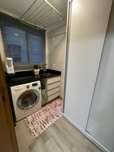a laundry room with a washing machine and a window at Apto duplex Lagoa do Violão in Torres