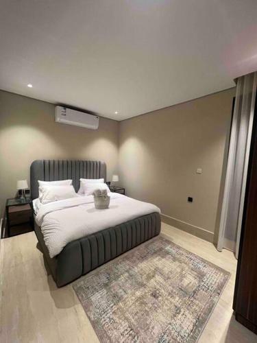 a bedroom with a large bed and a rug at Modern 3 Bedroom Flat in Riyadh