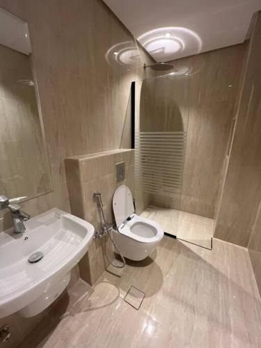 a bathroom with a white toilet and a sink at Modern 3 Bedroom Flat in Riyadh