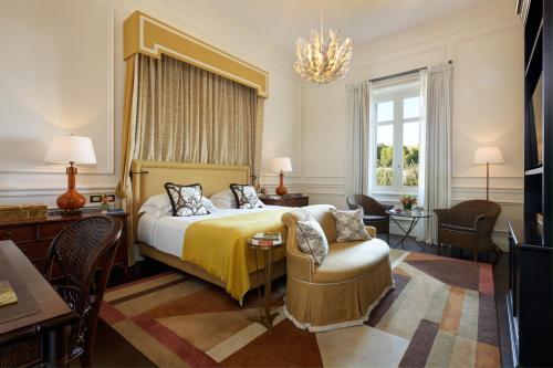 ein Hotelzimmer mit einem Bett und einem Stuhl in der Unterkunft Rocco Forte Villa Igiea in Palermo