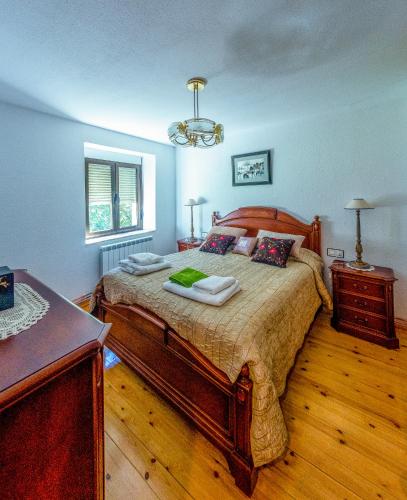 a bedroom with a large bed and a chandelier at La Casa de Quico in Nocedo de Curueño