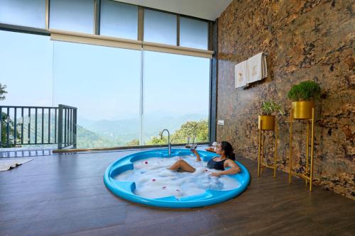 a woman sitting in a jacuzzi tub in a room at Elephant Passage in Munnar