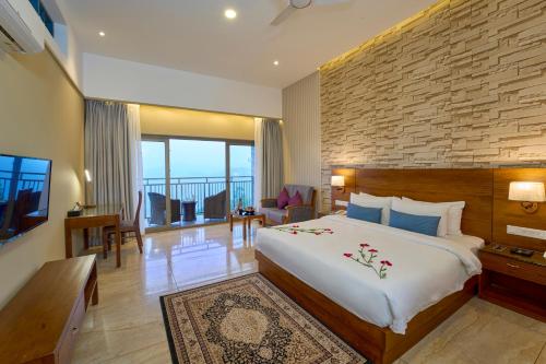 una camera con un grande letto e un muro di mattoni di Elephant Passage a Munnar