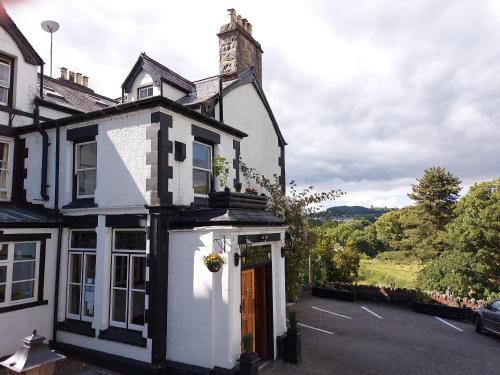 a white and black building with a door at Bron-Y-Graig in Corwen