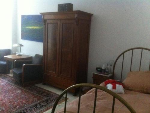 een slaapkamer met een grote houten kast en een bed bij Privatzimmer Wagner in Hannover