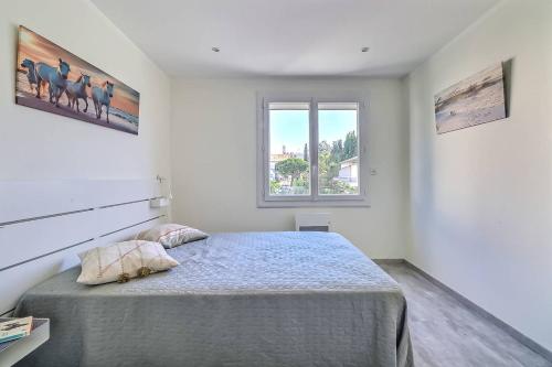 um quarto com uma cama e uma janela em Appartement T3 moderne au Grau du roi em Le Grau-du-Roi