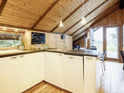een keuken met witte kasten en een groot raam bij 6 person holiday home in Stubbek bing in Stubbekøbing