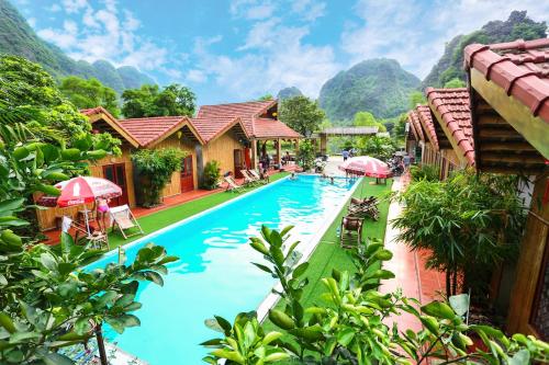 a pool at a resort with mountains in the background at For You Homestay in Ninh Binh