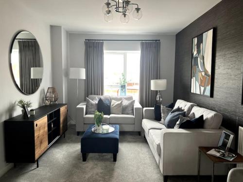 a living room with a white couch and a mirror at Waterside House in Leicester