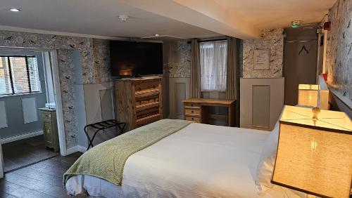 1 dormitorio con 1 cama grande y TV en College Arms en Stratford-upon-Avon