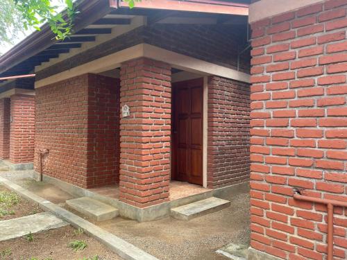 a brick entrance to a brick building with a wooden door at Hotel Lake Park in Polonnaruwa