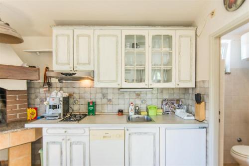 una cocina con armarios blancos y fregadero en Villa Ana, en Zadar