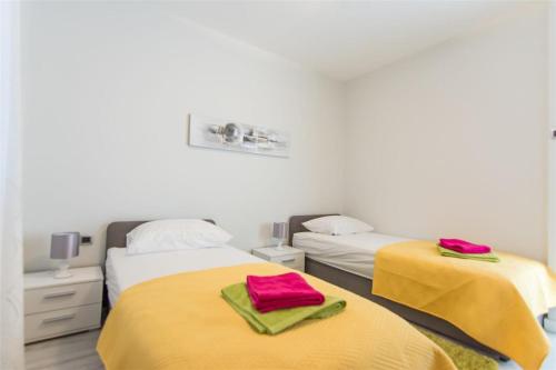 2 camas en una habitación con sábanas amarillas y rojas en Villa Ana, en Zadar