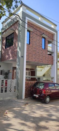 a red car parked in front of a brick building at ''Go Desert'' Homestay in Bhuj