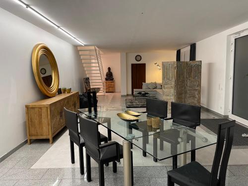 a dining room with a glass table and black chairs at Casa li surii in Mönchengladbach